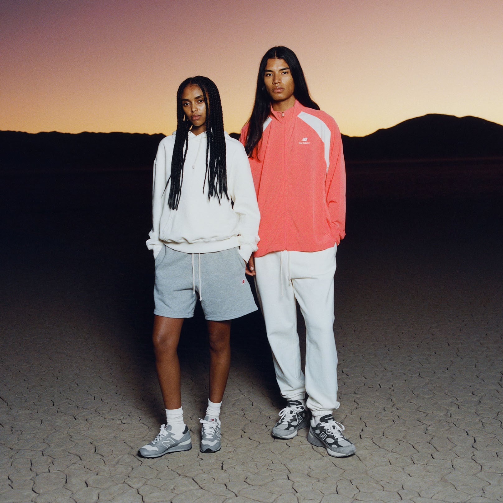  Two people with their hands in their pockets and wearing New Balance.