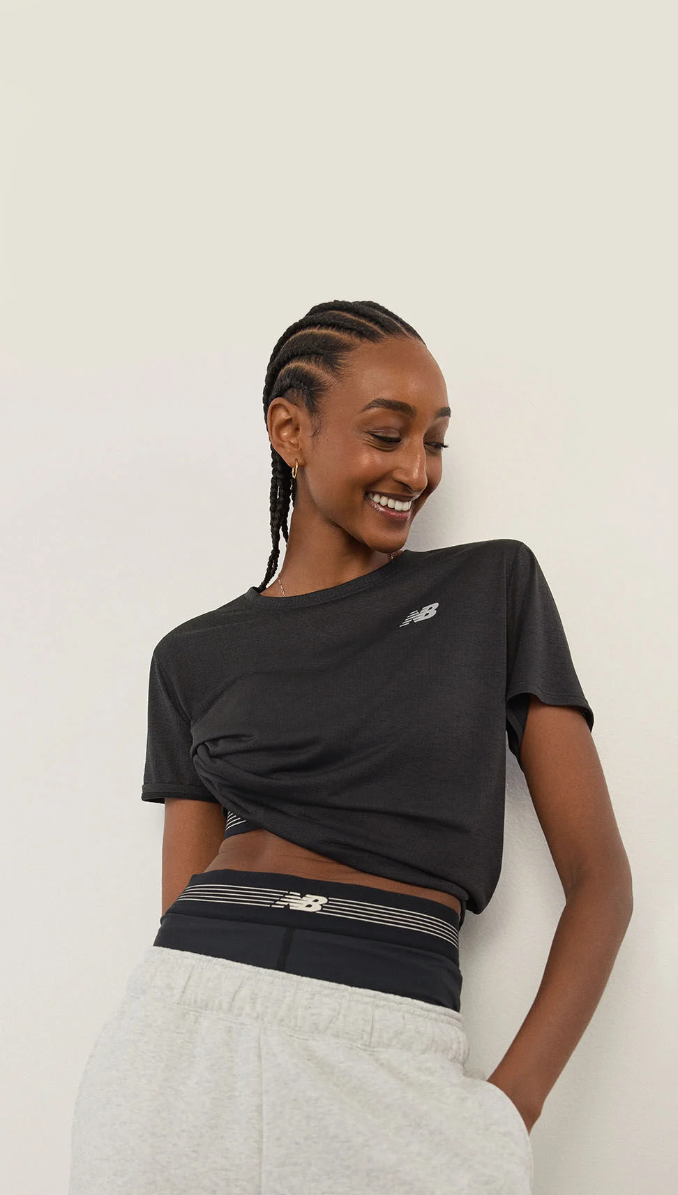 A woman standing in front of a white wall.