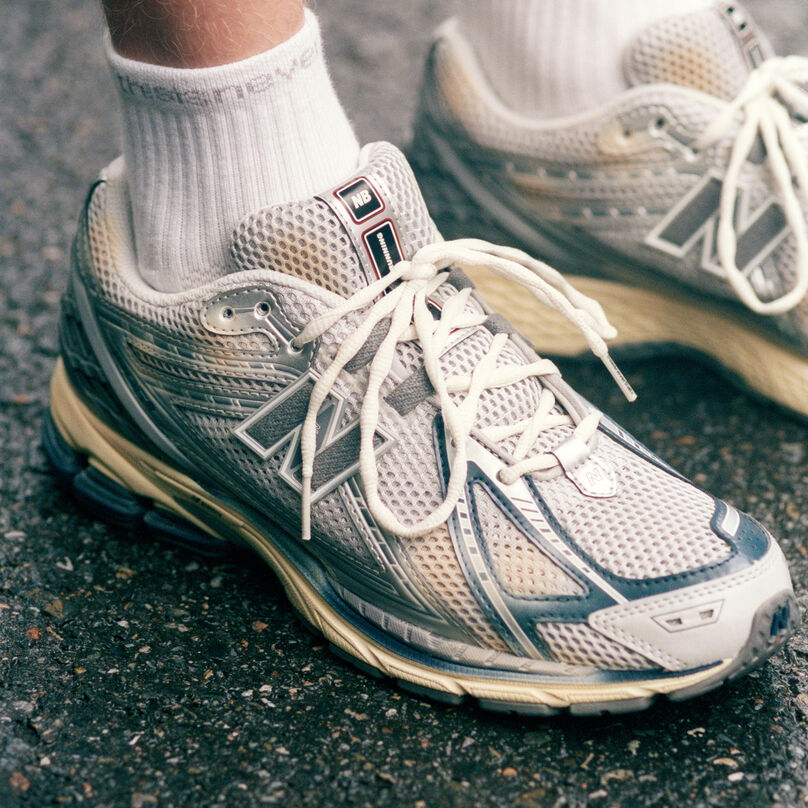 A close-up of the 1906 from the New Balance x thisisneverthat collab being worn by someone on concrete.