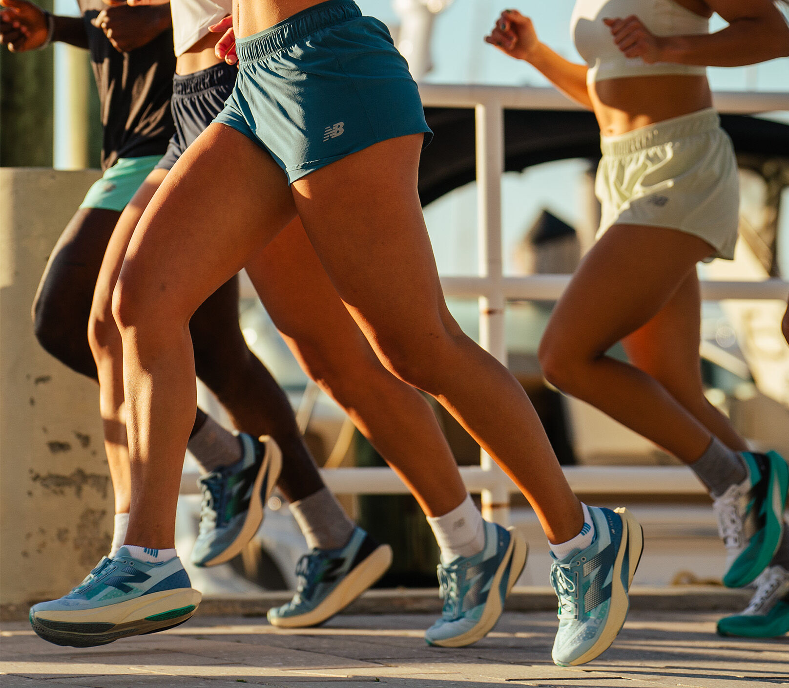 A group of people running on a street, with all of them wearing FuelCell Rebel sneakers.